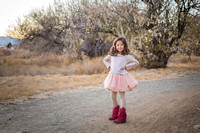 Six year old posing with pink tutu and pink cowboy boots at dusk