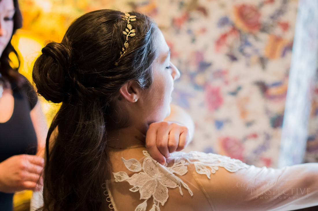 Bride putting on her wedding gown on wedding day