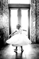 Black and white image of flower girl dancing in her dress