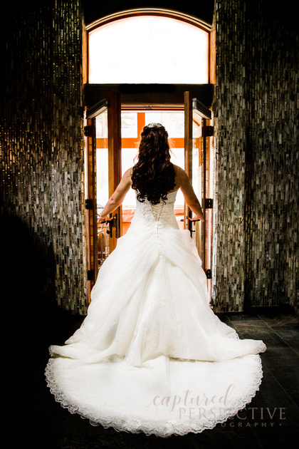 bride looking out the window on her wedding day in her wedding dress